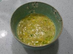 打散的鸡蛋中放入切碎的青椒丁（如果不喜欢辣可以不放）