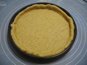 批萨盘上涂上一层薄薄的黄油或色拉油，将擀好的面皮放入批萨盘内，用手按压面皮，把面皮撑至与盘子同样大，边缘挤出一圈圆边，用叉子在饼皮上刺出排气孔，再度发酵约20分钟，饼边缘刷上全蛋液