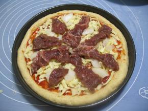 再撒上2/3切成细条的马苏里拉芝士，在放上洋葱块，在放上腌好的黑胡椒牛肉