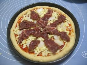 再撒上2/3切成细条的马苏里拉芝士，在放上洋葱块，在放上腌好的黑胡椒牛肉