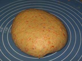 面和胡萝卜倒入盆中加入盐，奶粉，糖，酵母，胡萝卜汁，鸡蛋揉成面团