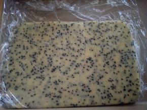 将面团包进一块大的保鲜膜中，用擀面仗擀成厚约0.5CM左右的方形（四周可借助刮板整形），醒半小时；