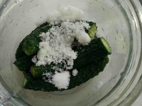 取容器，把小黄瓜在容器底部摆好，撒一层糖。小黄瓜长，可以切一段一段的。最好没有缝隙。压实。