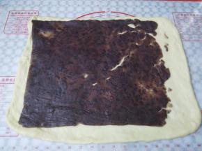 把红豆沙剪掉保鲜膜，小心的铺到面皮上