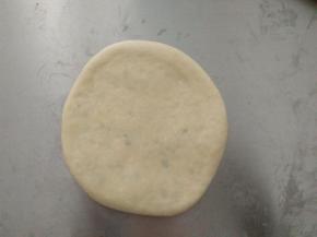 用擀面杖擀成圆饼形状，盖上保鲜膜松驰10分钟