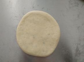 用擀面杖擀成圆饼形状，盖上保鲜膜松驰10分钟