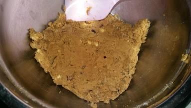 4. 加入核桃和蔓越莓干，搅拌均匀； 
   然后倒入低粉，翻拌均匀； 套入保鲜袋，按压成团；