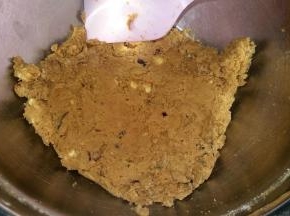 4. 加入核桃和蔓越莓干，搅拌均匀； 
   然后倒入低粉，翻拌均匀； 套入保鲜袋，按压成团；