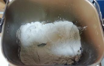 1、面包机依次放入牛奶+蛋液+糖+盐+面包粉，在面粉上戳个洞，放入酵母。启动揉面程序，面包机盖子打开（防止温度过高)，揉至扩展阶段（抻开面团，可以拉出透明的不紧实的薄膜，戳个洞，洞口呈锯齿状），加入软化的黄油。