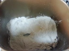 1、面包机依次放入牛奶+蛋液+糖+盐+面包粉，在面粉上戳个洞，放入酵母。启动揉面程序，面包机盖子打开（防止温度过高)，揉至扩展阶段（抻开面团，可以拉出透明的不紧实的薄膜，戳个洞，洞口呈锯齿状），加入软化的黄油。