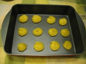 将面糊装入裱花袋把泡芙液挤在铺好油纸的烤盘上，注意每个之间要留足够的空隙