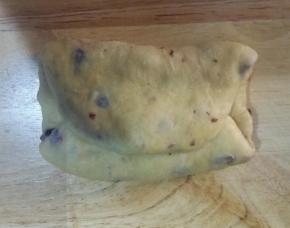 5、面团上下两边向中间对折，按扁压实，翻面