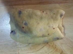 5、面团上下两边向中间对折，按扁压实，翻面