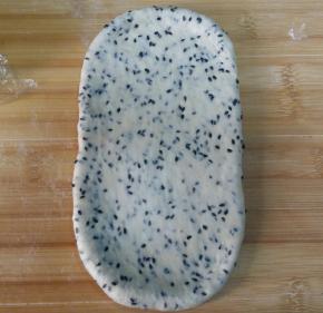 7. 取一松驰好的面团，按扁，擀长；