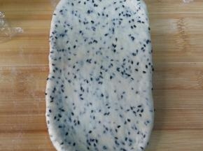 7. 取一松驰好的面团，按扁，擀长；