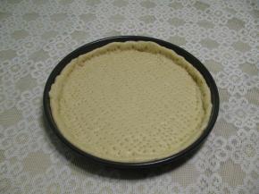 把发酵好有面团擀成圆型，把面饼放入披萨盘中,边缘略高一些，面饼上用叉子,叉满小眼,用来排空空气,防止烤时鼓包，放在温暖处发酵