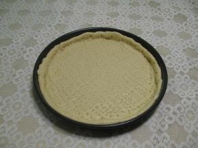 把发酵好有面团擀成圆型，把面饼放入披萨盘中,边缘略高一些，面饼上用叉子,叉满小眼,用来排空空气,防止烤时鼓包，放在温暖处发酵