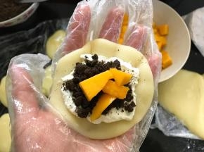 10、先放上打发好的淡奶油，再撒上奥利奥碎，再加入新鲜的芒果粒。