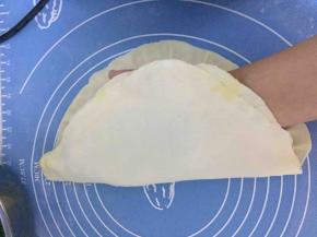 然后把饼皮翻一半在手掌中，另一只手慢慢拿起，因为软软的