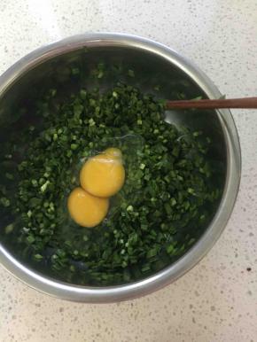 然后加入两颗鸡蛋，根据韭菜的多少来加鸡蛋，我这里就用了一小把韭菜，直接加鸡蛋饼烙出来更柔软，这里你也可以先把鸡蛋炒熟了