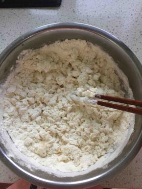 准备好适量面粉，慢慢倒入开水用筷子均匀搅拌，搅拌到如上图大颗粒状，开水要一点点放，不要一次倒太多，后面还要加少许凉水