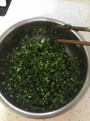 面团醒的过程中可以准备馅料，把韭菜洗干净，沥干水分或用厨房纸吸干水分，切成小段放入盆中加适量香油或者熟的食用油，先加油是为了防止切口处渗出水来