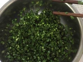 面团醒的过程中可以准备馅料，把韭菜洗干净，沥干水分或用厨房纸吸干水分，切成小段放入盆中加适量香油或者熟的食用油，先加油是为了防止切口处渗出水来