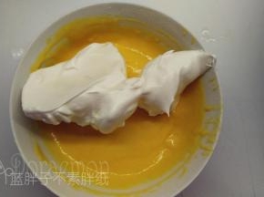 5.取1/3的蛋白霜加入到蛋黄糊中，用橡皮刮刀用翻拌的手法拌匀。
（这时候你可以看到，其实蛋白霜的状态是非常细腻有光泽的。这种状态是最佳的，很容易翻拌均匀。
手法：右手拿刮刀，左手转盆。刀从2点中位置入盆，刀刃垂直盆延直线穿到8点种位置，然后翻一下刀，将蛋糊翻上来。同时左手逆时针转盆。）