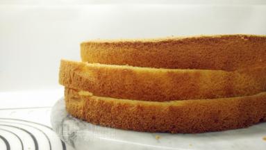 蛋糕晾凉之后脱模，平均分成三片。
（蛋糕分层一定要均匀，要锯齿刀，可以把蛋糕放在裱花台上面，边转动裱花台，边用锯齿刀先慢慢地划一圈，然后在轻轻的平行隔开）。