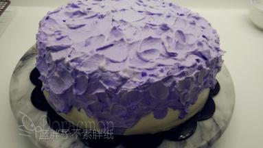 剩下的淡奶油先舀出一半，加入两滴紫色色素，打发到裱花状态，取出一半。之后剩下的加入剩下白色淡奶油的一半，继续打发到裱花状态，之后一样取出一半。最后将剩下的白色淡奶油和紫色淡奶油混合，如此我们就得到了三个不同程度的紫色淡奶油。
（这里的淡奶油需要打发到裱花状态，但是记得不要打过了，变得粗糙。）