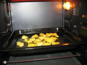 把切好的菠萝块放入烤盘中放入烤箱中烤出水份