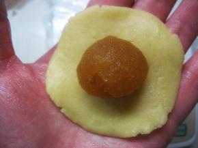 11. 取一面团放在掌心压扁，再将馅料放在面团上；