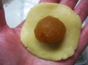 11. 取一面团放在掌心压扁，再将馅料放在面团上；