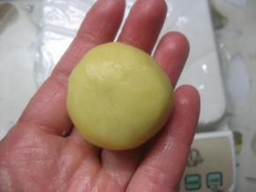 12. 左手大拇指轻压住馅料顶部，右手的大指拇和食指从面皮底部以转圈的方式慢慢往上推，然后合拢收口担紧。