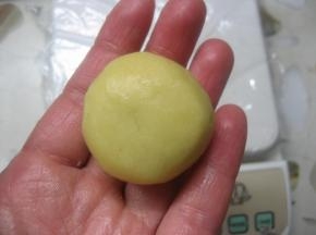 12. 左手大拇指轻压住馅料顶部，右手的大指拇和食指从面皮底部以转圈的方式慢慢往上推，然后合拢收口担紧。