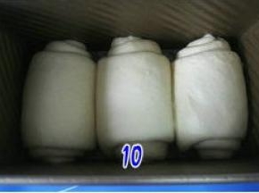 卷好的面团放入吐司模中，罩上保鲜膜放温暖处发酵；