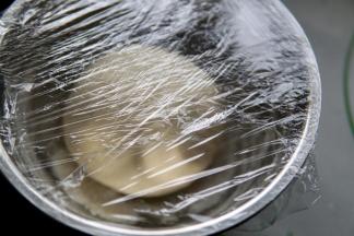 揉好的面团盖保鲜膜开始发酵。