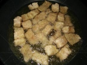 放入裹好面包糠的鳕鱼块中小火炸至一面金黄。