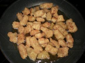 锅里油加热至九成热时，倒入刚才捞出的鳕鱼块进行第二次炸制。大火炸约两分钟左右，期间不停的翻动。