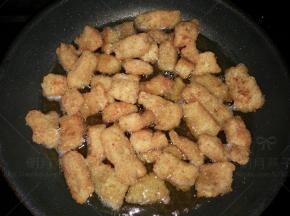 锅里油加热至九成热时，倒入刚才捞出的鳕鱼块进行第二次炸制。大火炸约两分钟左右，期间不停的翻动。