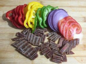 这个时间准备馅料：将洋葱，红椒，黄椒，青椒切成丝，西红柿切成片，牛排切成小条。