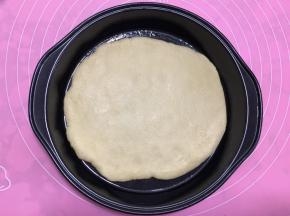 将擀好的饼皮放入披萨盘中。