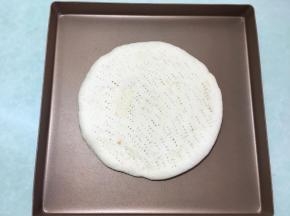 两个都做好后取一个烤好的披萨皮，放在烤盘里。