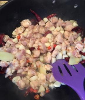  放入蒜段和鸡脆骨，翻炒。