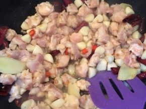  放入蒜段和鸡脆骨，翻炒。