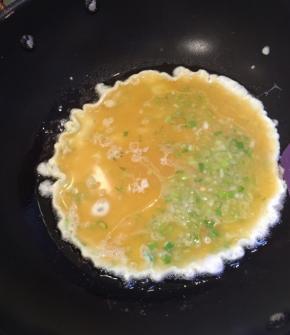 倒入蛋液，先不要翻动，转小火。慢慢把外圈和底部烙成稳定的型。