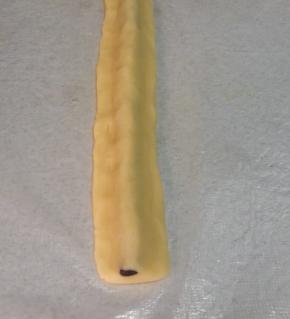 取15克原味面团，搓成21CM长条，按扁，覆盖在步骤9的可可长条（即鼻子）上，轻轻捏合，使原味面团跟熊猫鼻子完全贴合。