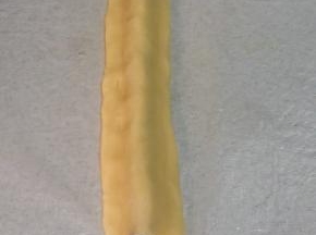 取15克原味面团，搓成21CM长条，按扁，覆盖在步骤9的可可长条（即鼻子）上，轻轻捏合，使原味面团跟熊猫鼻子完全贴合。