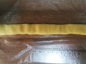 取38克原味面团，搓成21CM长条，按扁。然后放在保鲜膜或保鲜袋上；