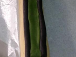 取剩下的两份11克可可长条（耳朵），放在步骤13的面团顶部两侧 ；
取15克抹茶面团，搓成21CM长条，稍稍按扁，放在两条可可长条中间。将可可长条跟抹茶长条捏紧，不留缝隙。此时可将面团冷冻一至两分钟，为下步抹茶面团包裹时不变形做准备。